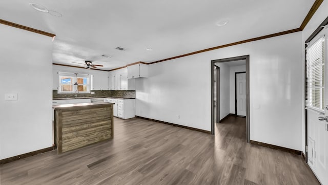 760 College Farm, Stephenville, TX 76401 - kitchen with ornamental molding, dark wood finished floors, white cabinetry, and baseboards