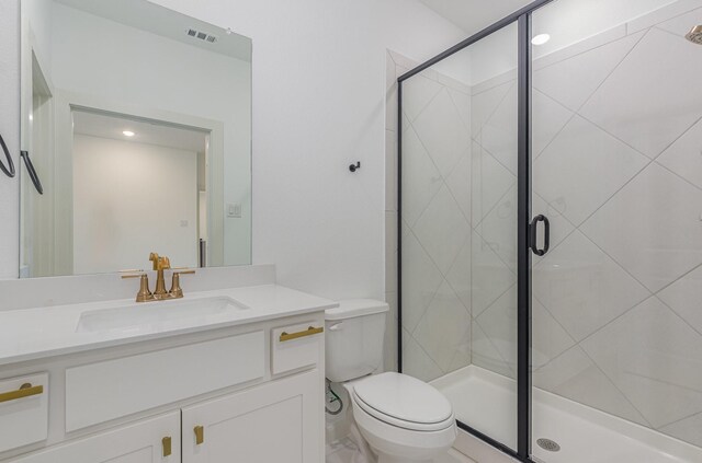 bathroom featuring toilet, visible vents, a shower stall, and vanity