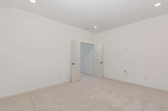 empty room featuring baseboards, light carpet, recessed lighting, and visible vents