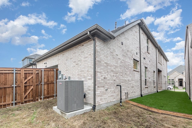 view of home's exterior with central air condition unit, a yard, a gate, and a fenced backyard