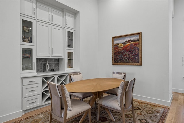 dining space with light wood finished floors and baseboards