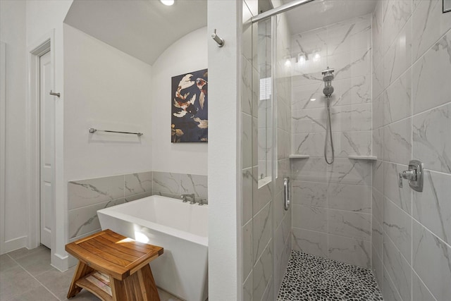 full bathroom featuring a stall shower, a freestanding tub, and vaulted ceiling