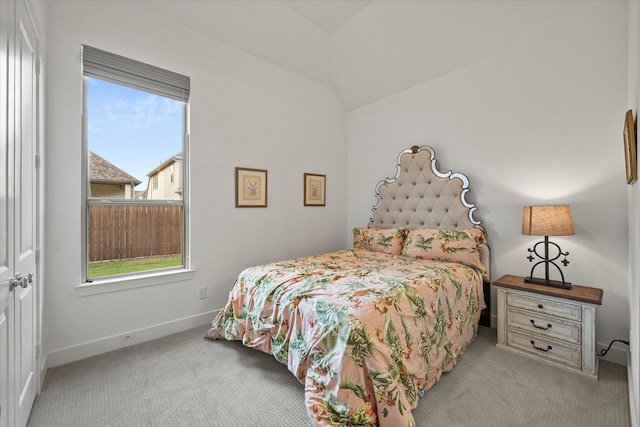 carpeted bedroom featuring vaulted ceiling and baseboards