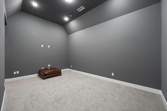 spare room featuring lofted ceiling, carpet, and baseboards