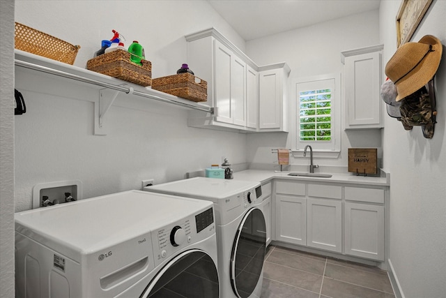 clothes washing area featuring washer and dryer, cabinet space, tile patterned flooring, and a sink