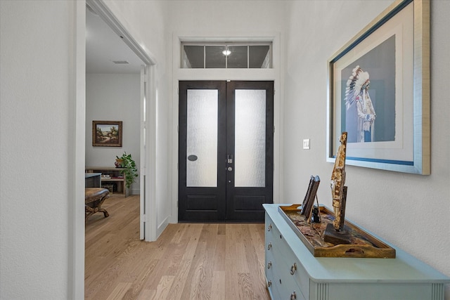 foyer with visible vents, light wood-type flooring, and french doors