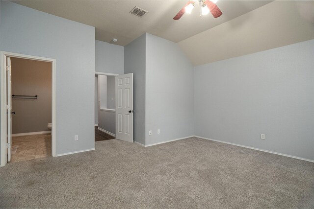 unfurnished bedroom featuring carpet flooring, visible vents, vaulted ceiling, and baseboards