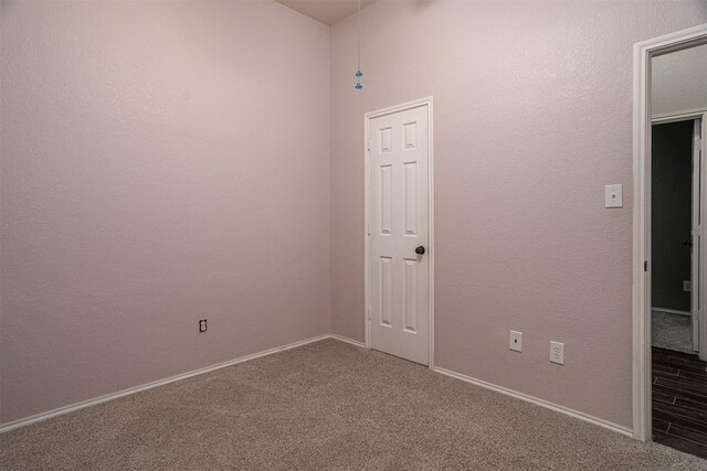 carpeted spare room featuring baseboards