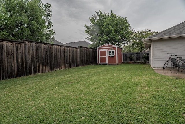 view of yard with an outdoor structure, a shed, a fenced backyard, and a patio area