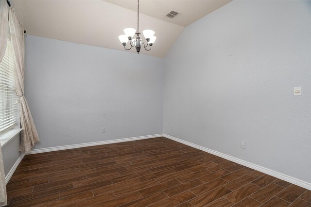 empty room with lofted ceiling, visible vents, baseboards, an inviting chandelier, and dark wood-type flooring