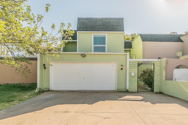 view of front of property with a shingled roof, stucco siding, a gate, driveway, and an attached garage