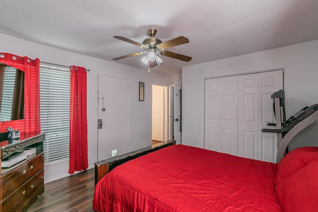bedroom with a textured ceiling, dark wood-style floors, baseboards, a closet, and a ceiling fan