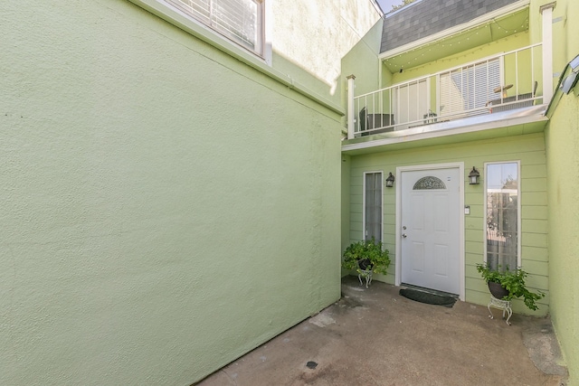 doorway to property featuring stucco siding and a balcony
