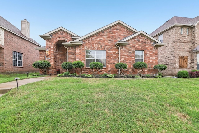 traditional-style house with brick siding and a front yard