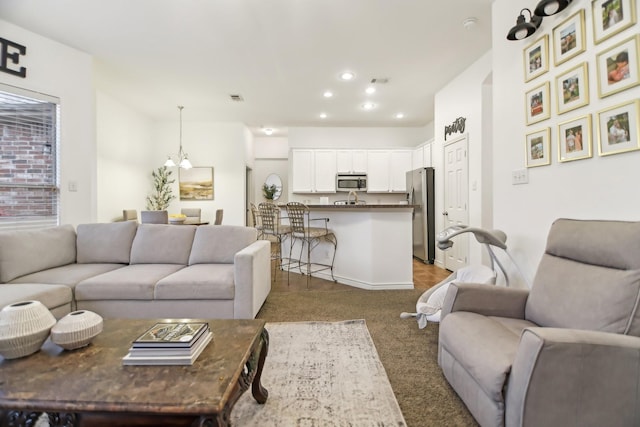 carpeted living area with recessed lighting, baseboards, a chandelier, and visible vents