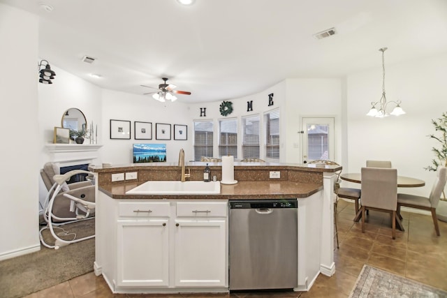 kitchen featuring visible vents, stainless steel dishwasher, a sink, ceiling fan with notable chandelier, and open floor plan