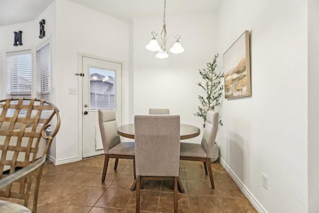 dining space featuring tile patterned flooring, baseboards, and a chandelier
