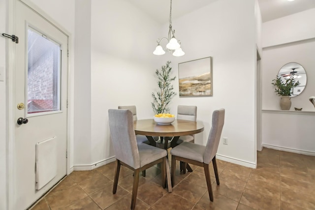 tiled dining room featuring baseboards and a chandelier