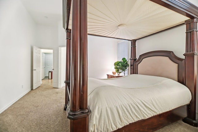 bedroom with baseboards and light colored carpet