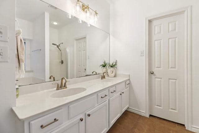 bathroom with double vanity, a sink, tile patterned floors, and a shower