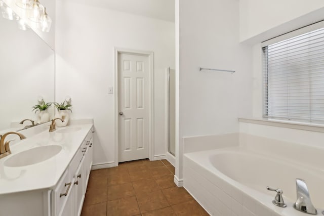 full bath featuring a sink, tile patterned flooring, double vanity, and a bath
