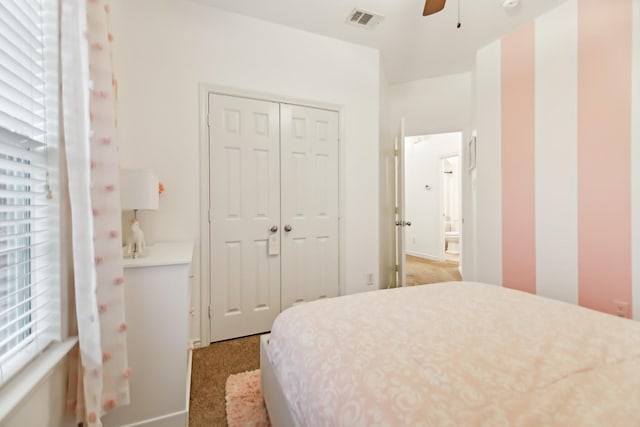 bedroom featuring a ceiling fan, a closet, light colored carpet, and visible vents