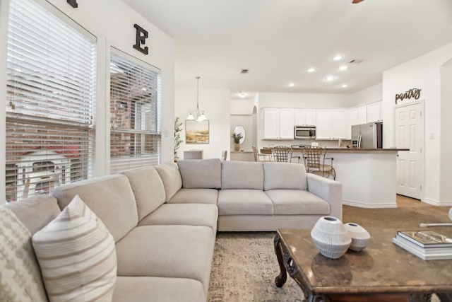 living room featuring recessed lighting, baseboards, and light colored carpet