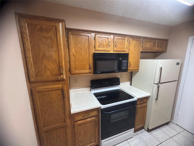 kitchen with black microwave, range with electric cooktop, light countertops, and freestanding refrigerator