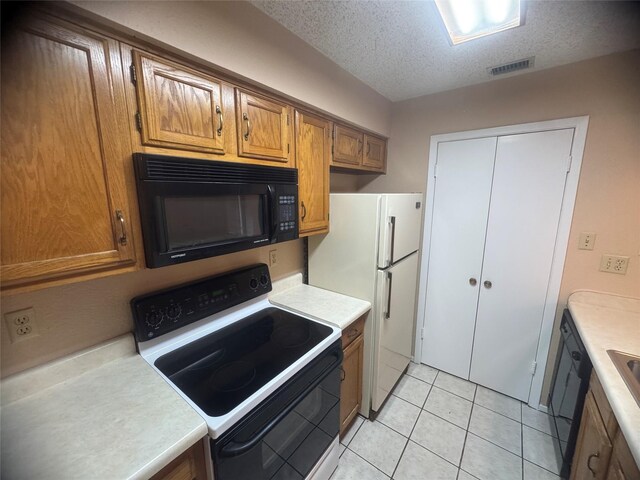kitchen with brown cabinetry, light countertops, black appliances, visible vents, and a textured ceiling