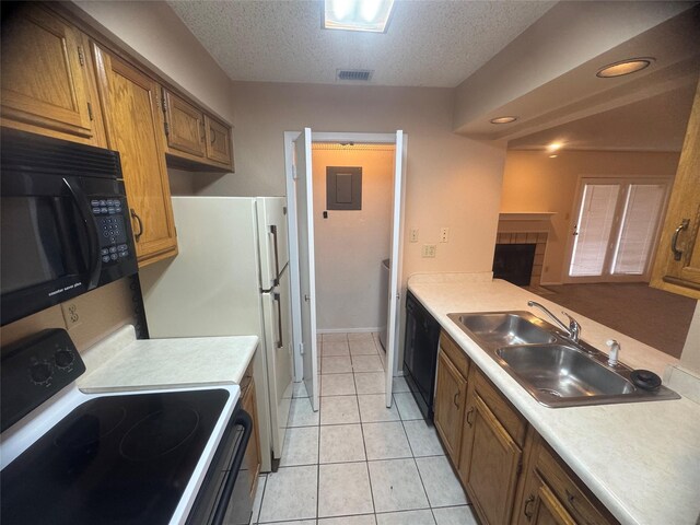kitchen featuring brown cabinets, a sink, visible vents, light countertops, and black appliances