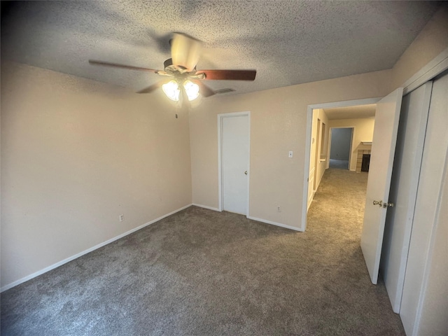 unfurnished bedroom with a textured ceiling, ceiling fan, a closet, and carpet