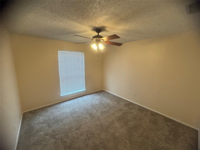 empty room with dark colored carpet, a textured ceiling, visible vents, and a ceiling fan