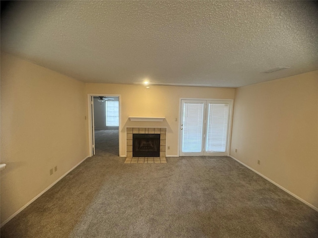 unfurnished living room with a fireplace, carpet, baseboards, and a textured ceiling