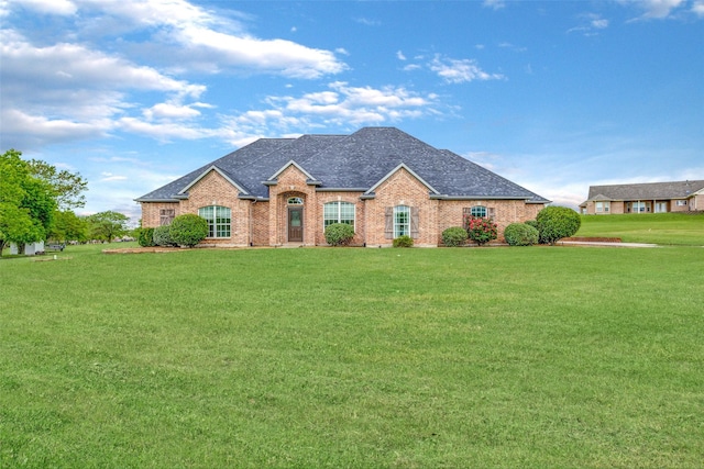 single story home with brick siding, a front lawn, and roof with shingles