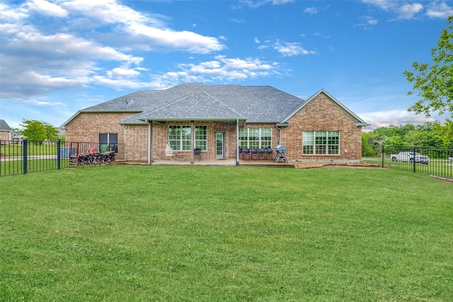 back of house with a lawn, roof with shingles, and brick siding