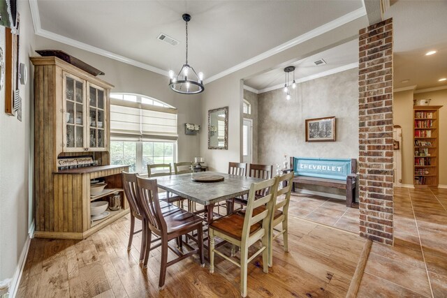 dining area featuring visible vents, light wood-style floors, ornamental molding, and baseboards