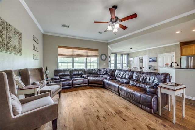 living area featuring a ceiling fan, visible vents, hardwood / wood-style flooring, and a healthy amount of sunlight
