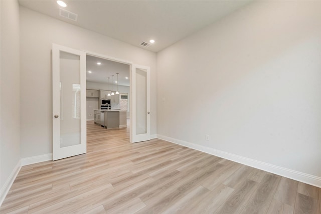 unfurnished room with recessed lighting, visible vents, light wood-style flooring, and baseboards