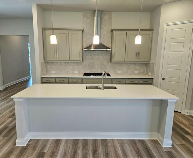 kitchen with dark wood-style floors, gray cabinets, wall chimney exhaust hood, and a sink