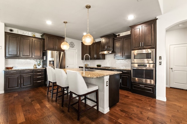 kitchen with dark brown cabinetry, a sink, backsplash, and stainless steel appliances