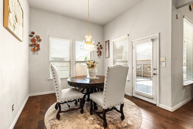 dining room with dark wood finished floors, baseboards, an inviting chandelier, and a healthy amount of sunlight