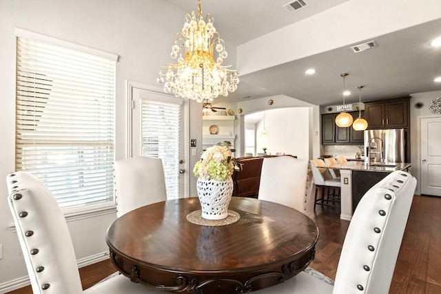 dining room with dark wood-style floors, an inviting chandelier, visible vents, and plenty of natural light