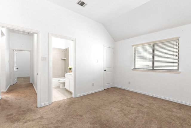 unfurnished bedroom featuring attic access, light carpet, baseboards, visible vents, and lofted ceiling