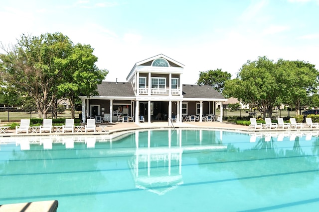 community pool with a patio area and fence