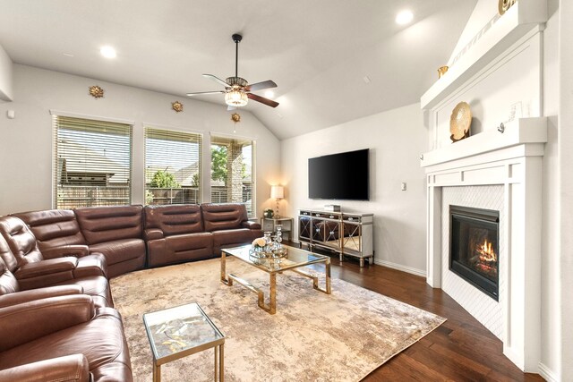 living room with dark wood finished floors, recessed lighting, vaulted ceiling, a glass covered fireplace, and a ceiling fan