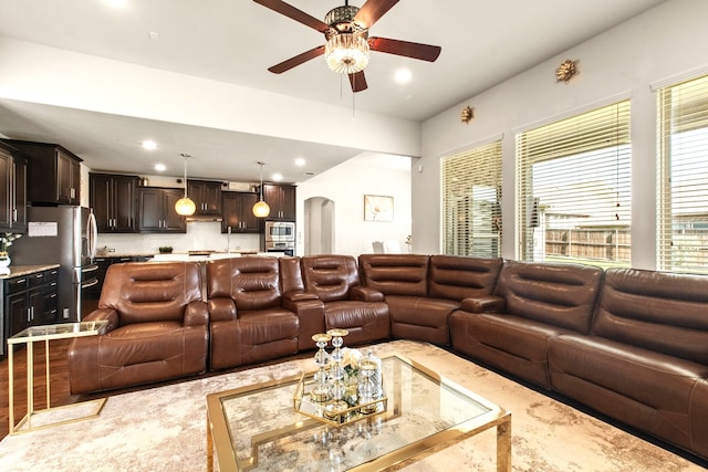 living room featuring recessed lighting, arched walkways, and a ceiling fan