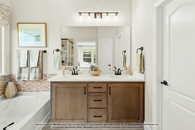 bathroom featuring double vanity, a garden tub, a stall shower, and a sink