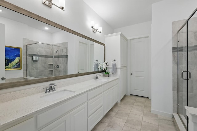 bathroom featuring a stall shower, double vanity, and a sink