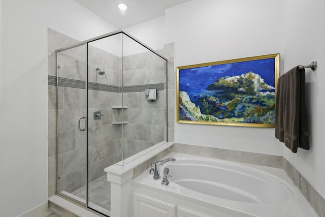 bathroom featuring a garden tub and a shower stall