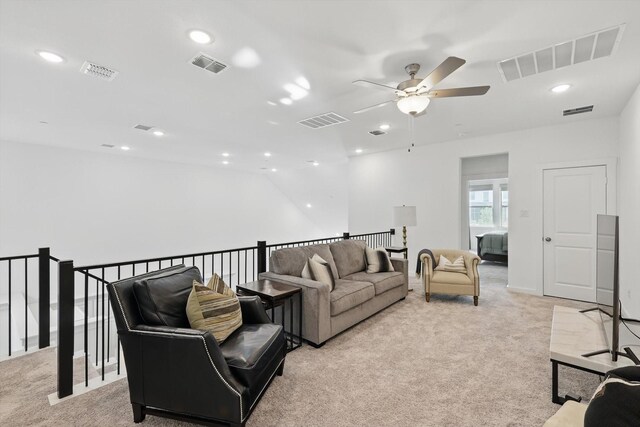 living area with visible vents and light carpet